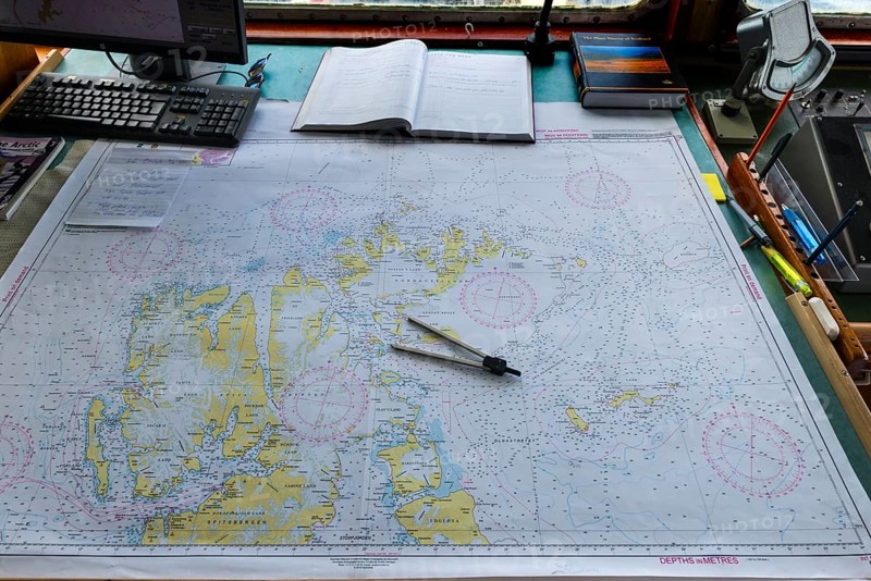 Map and compass on the bridge of the expedition ship