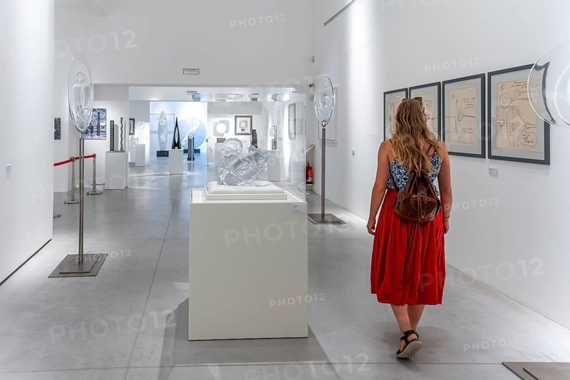 Young woman in the glass museum looking at hand-blown glass
