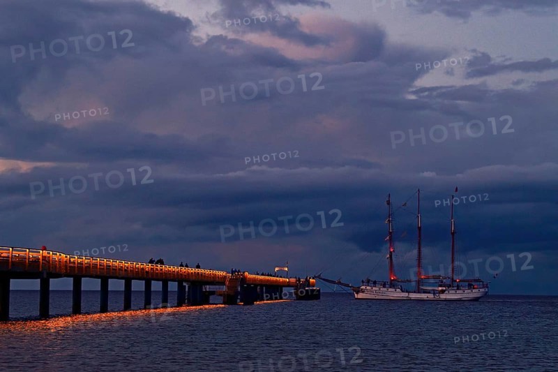 Evening atmosphere jetty with three-master sailing boat