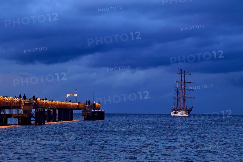 Evening atmosphere jetty with three-master sailing boat