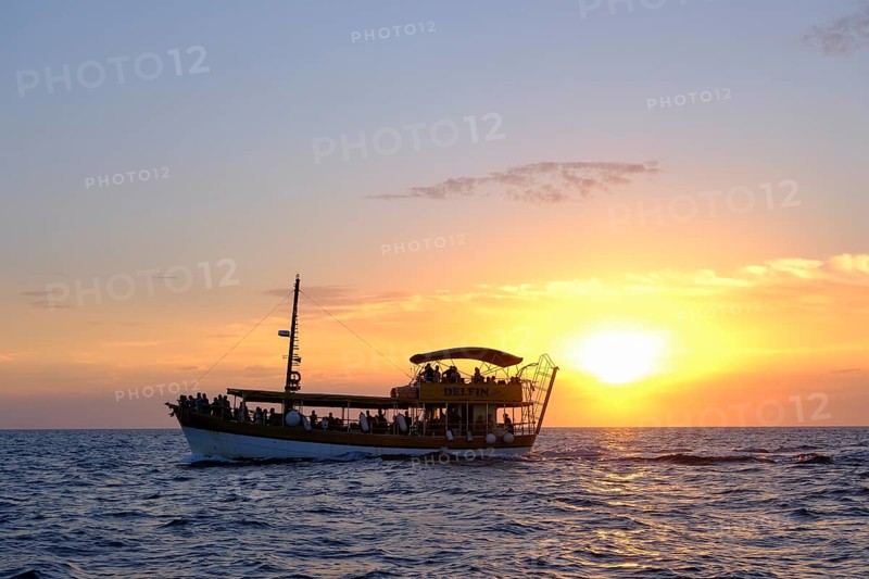 Tourist boat in the sea at sunset