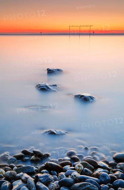 View from Arbon over Lake Constance at sunrise with stones in the foreground
