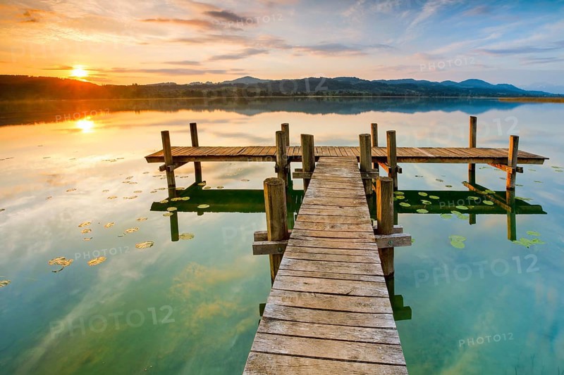 Wooden footbridge on Lake Pfaeffikon at sunrise