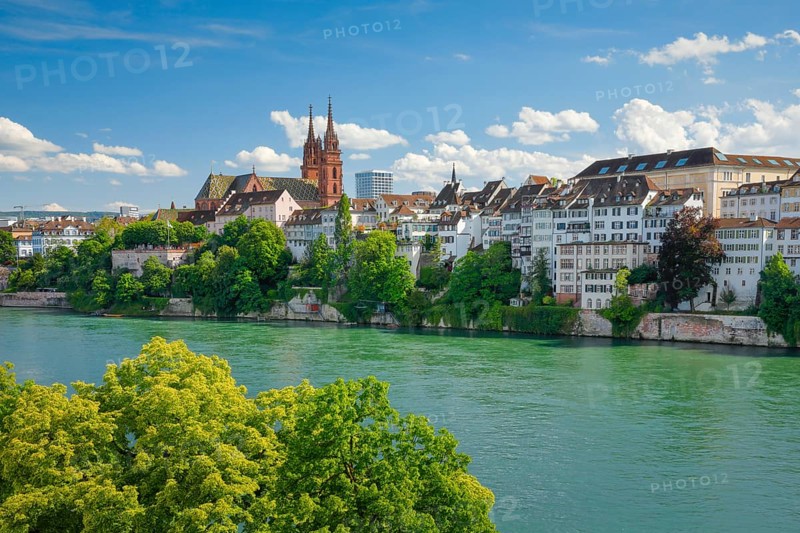 View of the Basel Cathedral in the middle of the old town of Basel with the turquoise Rhine River in the foreground