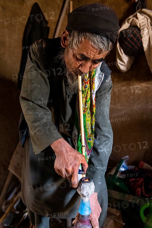 Sufi man preparing his marihuana pipe