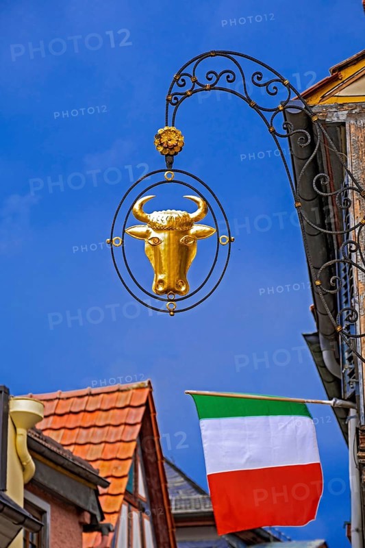 Guild sign of the Gasthof Zum Ochsen above an Italian national flag in Ladenburg