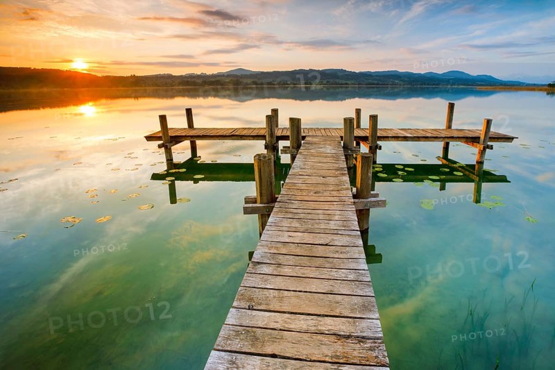 Wooden footbridge on Lake Pfaeffikon at sunrise