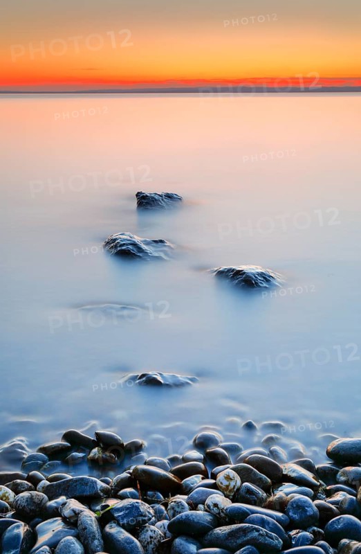 View from Arbon over Lake Constance at sunrise with stones in the foreground
