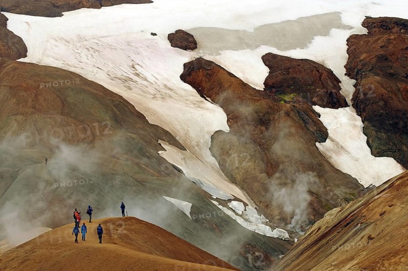 People on a hiking trail in front of snowfields