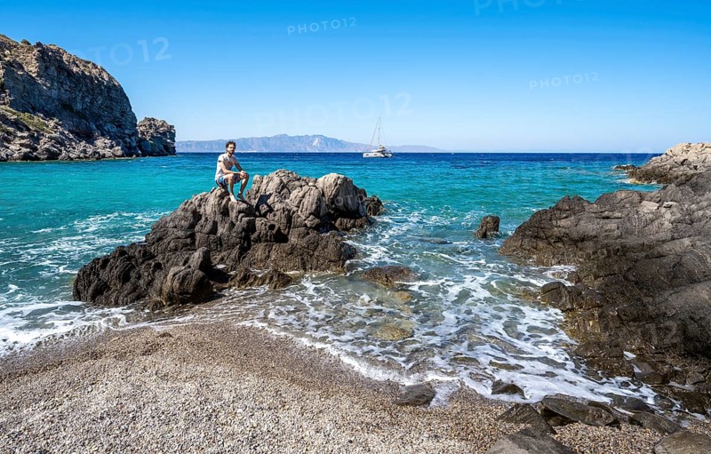 Young man sitting on a rock