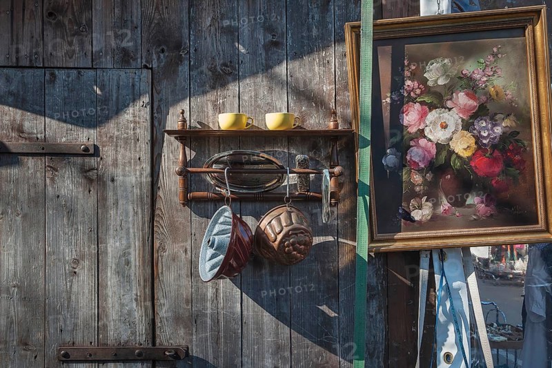 Paintings and bric-a-brac on old wooden wall