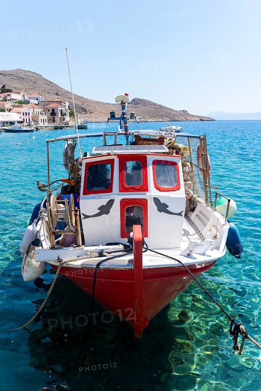 Fishing boat in Halki harbour with turquoise blue water