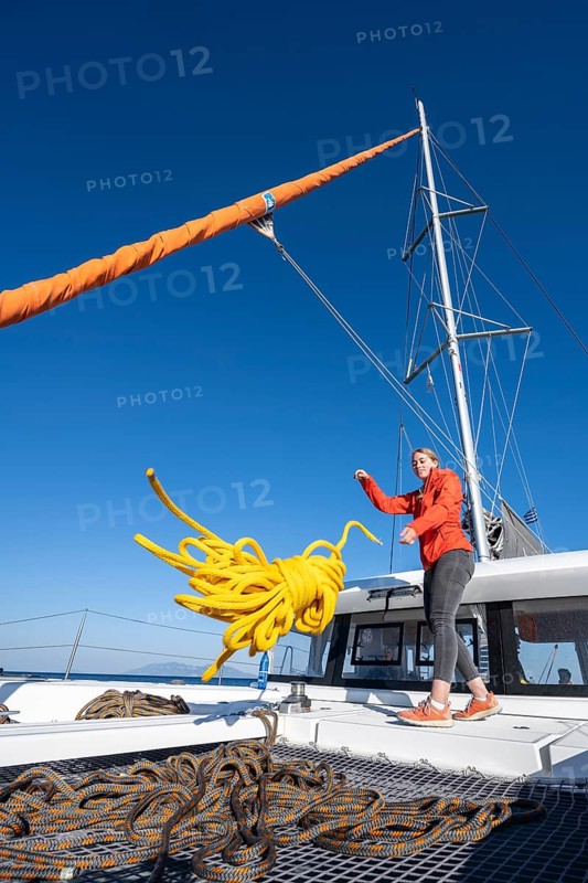 Young woman throws a rope on deck
