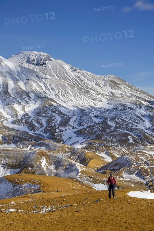 Woman in front of snowy mountains Fannborg and Snaekollur in the hot spring area Hveradalir
