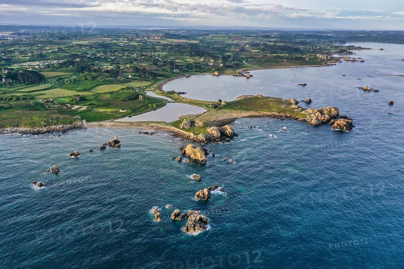 Wide angle drone shot from the Atlantic Ocean onto the granite coast of Plougrescant with a view of the house between the rocks (Le gouffre de Plougrescant)