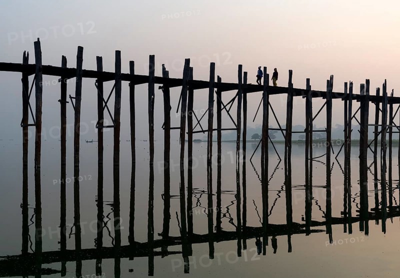 People walk on the U Bein bridge over Taungthaman Lake in Amarapura near Mandalay