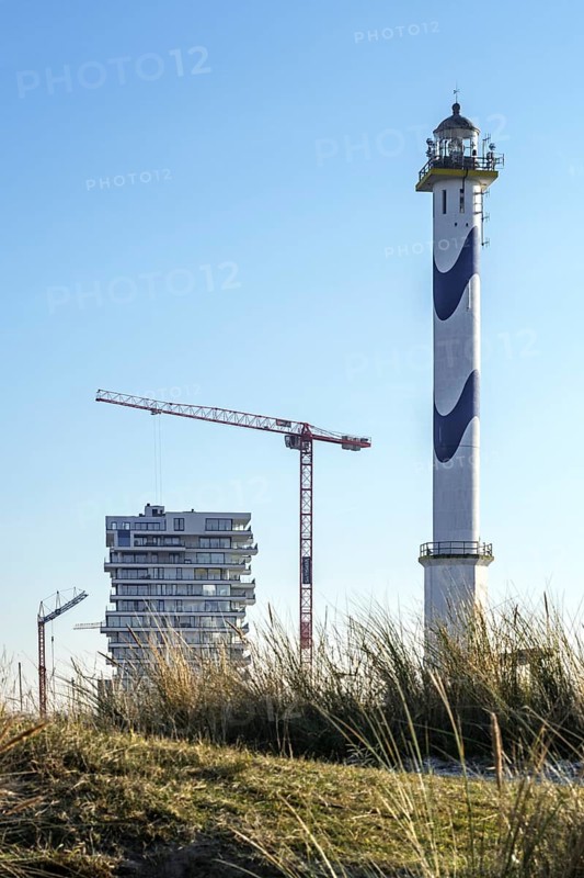 Lange Nelle lighthouse and new flats under construction for the Oosteroever real estate project in the port of Ostend on the Belgian North Sea coast