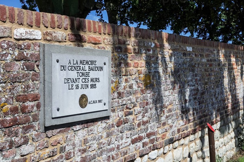 Memorial plaque to the fallen French General Bauduin in front of the garden wall of the Chateau d'Hougoumont