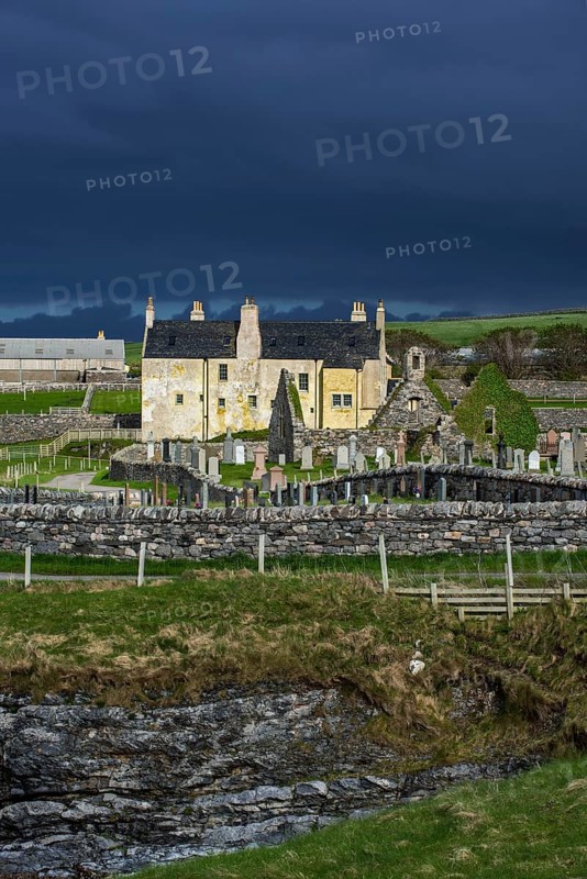 Black storm clouds rolling in over ruined church and the Balnakeil House