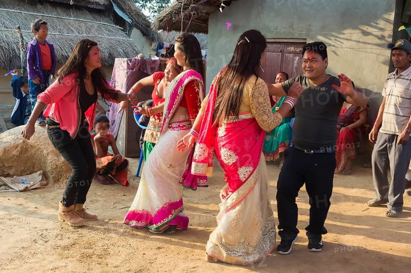 People of the Tharu ethnic group dance and laugh during a wedding
