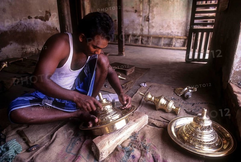 Artisan working on brass lamp