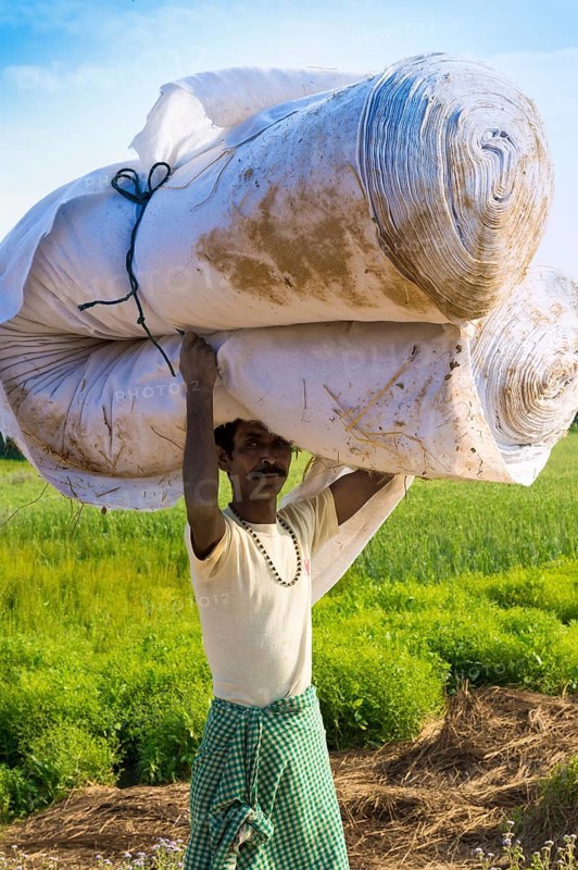 Nepalese man from the Tharu ethnic group carrying large handkerchief roll on his head