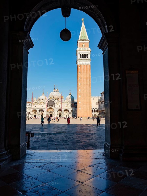 View through an archway onto St Mark's Square with the Campanile bell tower and the Basilica of St Mark