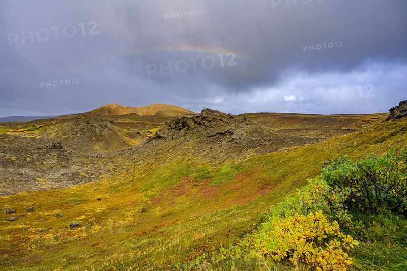 Rainbow over volcanic landscape and colourful autumn colours