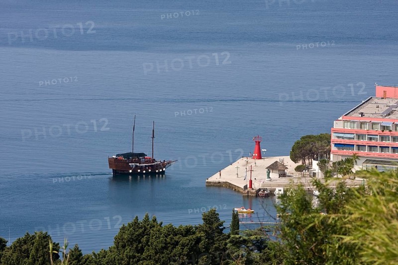 Antique sailing boat in front of a hotel complex in Lucija