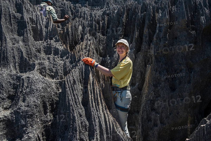 Woman climbing through rock needles of karst landscape