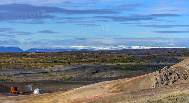 Geothermal plant and snow-capped mountains in the west