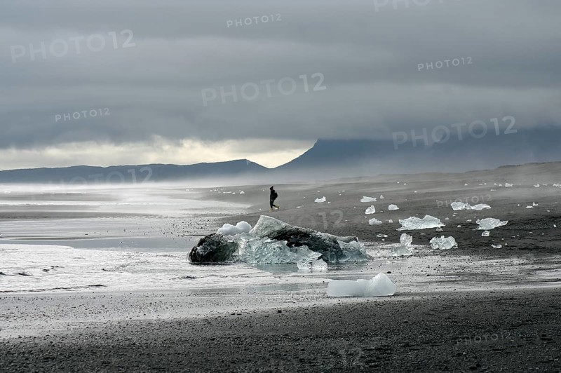 Pieces of ice lying on wide black beach