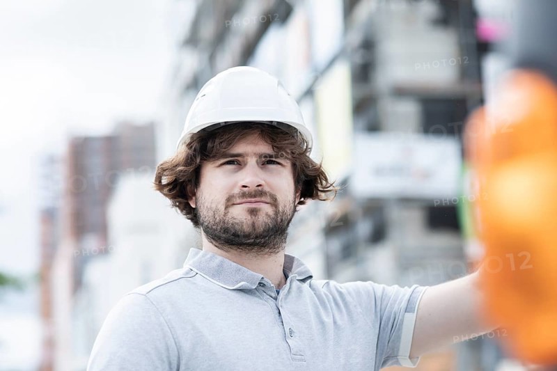 Technician with beard middle aged and working outside with polo shirt and helmet