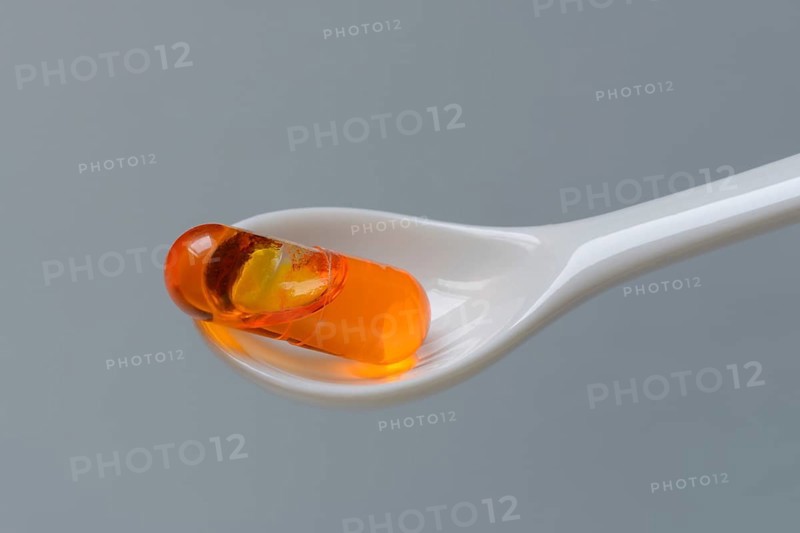 Capsule with omega-3 fatty acids in spoon