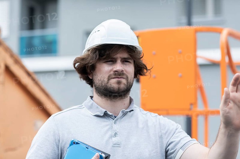 Technician with beard middle aged and working outside with polo shirt and helmet
