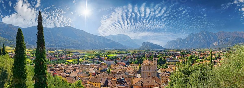 Old idyllic town surrounded by mountains with the Collegiata dell'Assunta church and fascinating sky