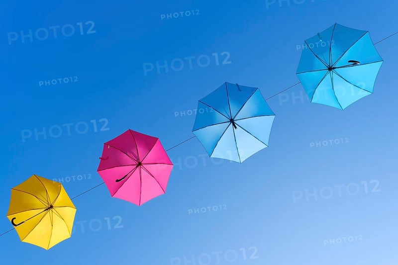 Coloured umbrellas against a blue sky