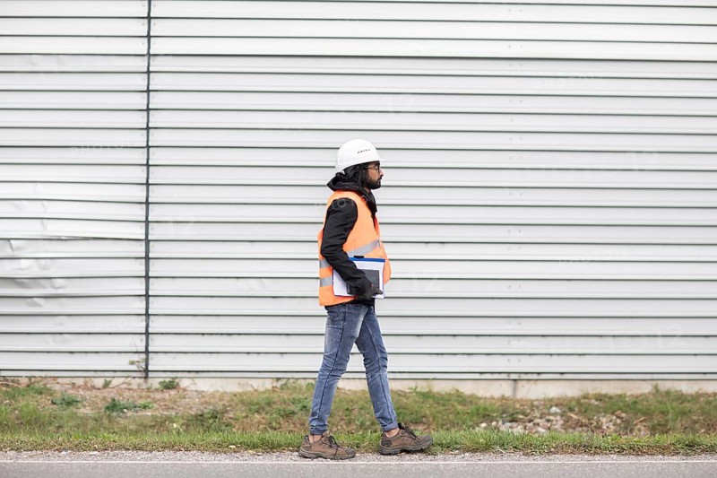 Technician with beard and helmet walking
