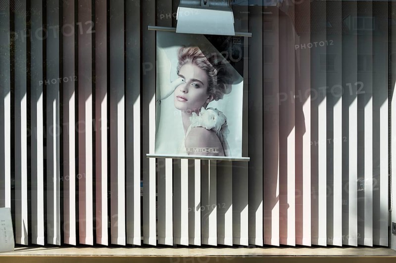 Advertising poster in the shop window of a hairdressing salon