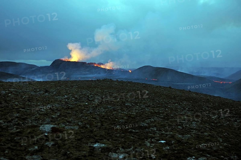 Stone desert and active volcano in the background