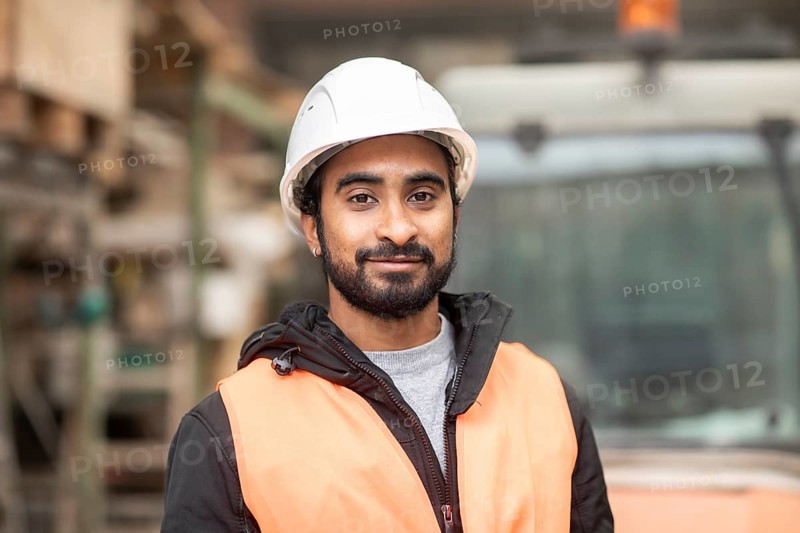 Technician with beard and helmet works in a workshop