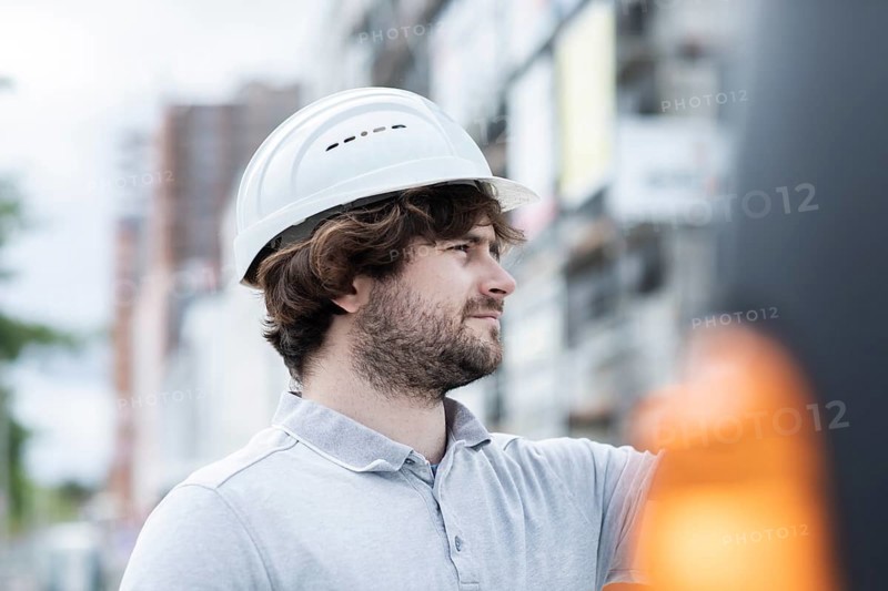 Technician with beard middle aged and working outside with polo shirt and helmet