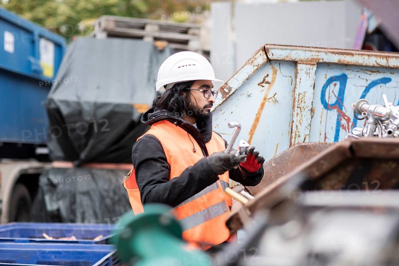 Technician with beard and helmet working in a recycling yard
