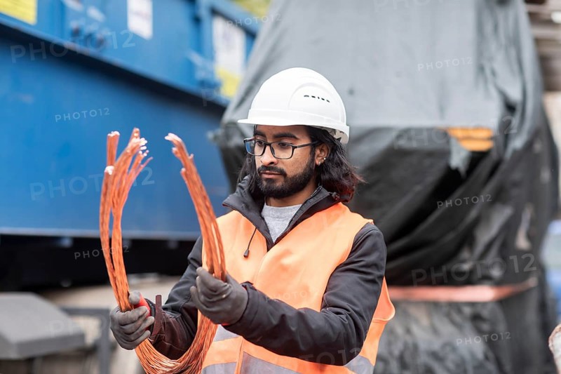 Technician with beard and helmet working in a recycling yard