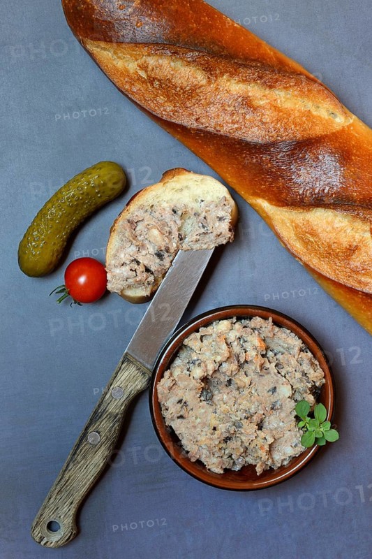 A bowl of meat terrine and slice of bread
