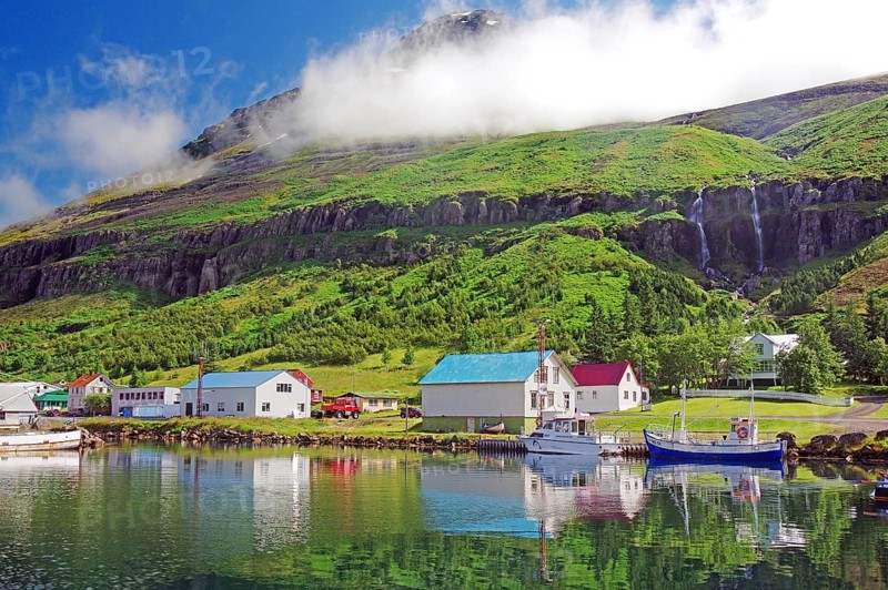 Boats and small houses reflected in the fjord