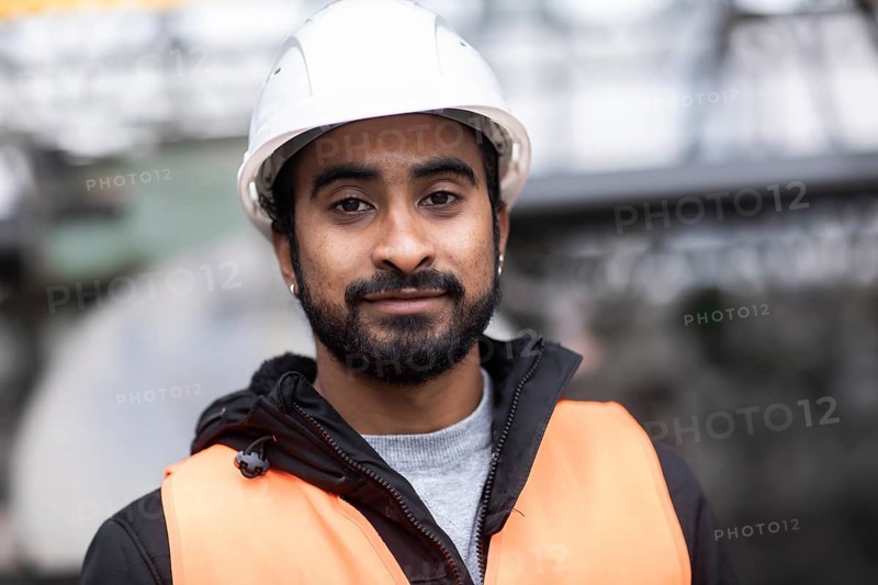 Technician with beard and helmet works in a workshop