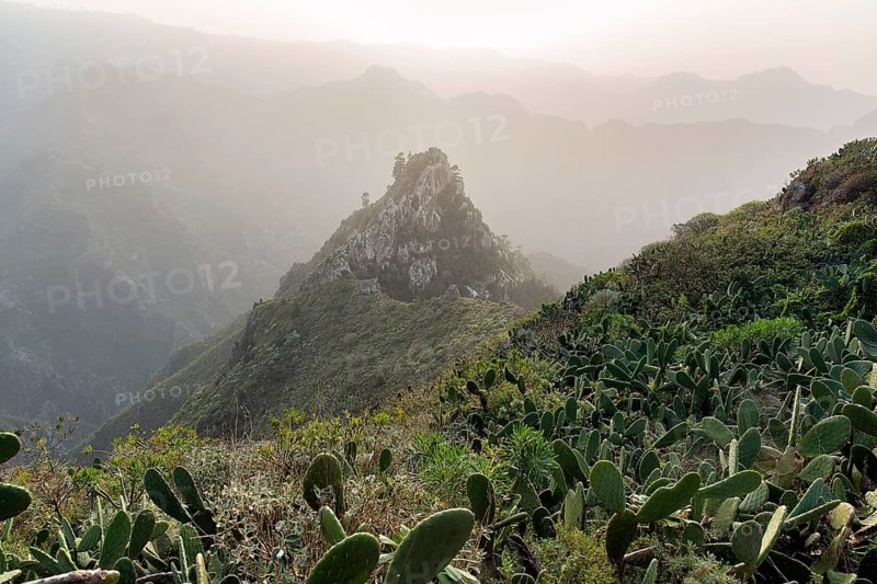 View of rock formation and mountain range in the evening haze