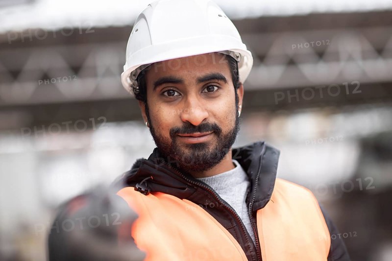 Technician with beard and helmet works in a workshop