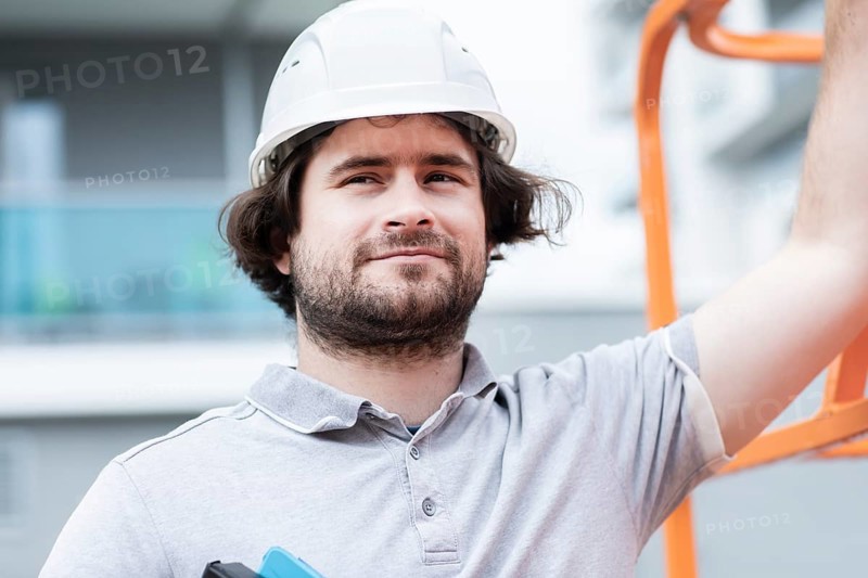 Technician with beard middle aged and working outside with polo shirt and helmet